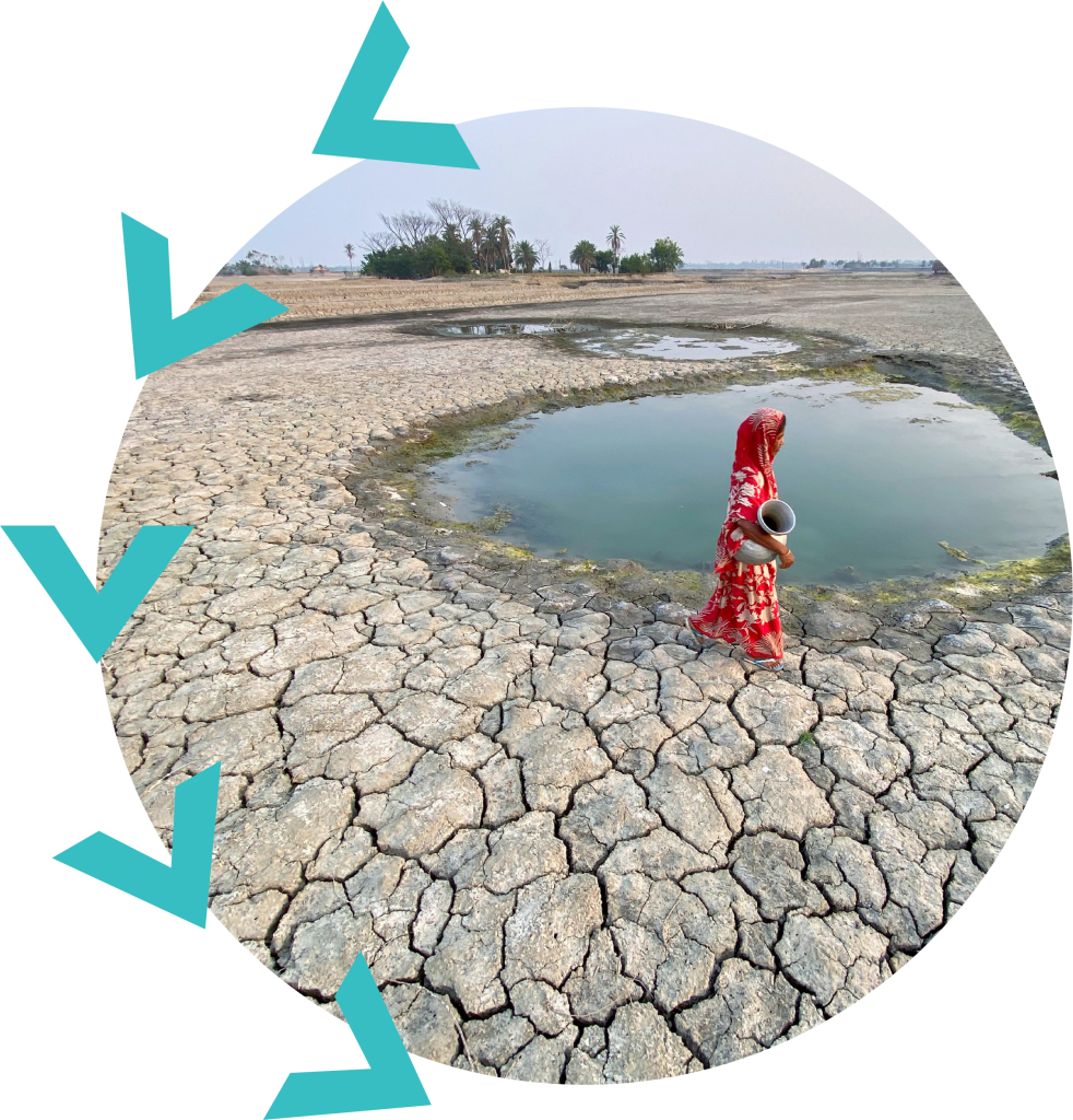 Woman carrying a pot near a dirty pond surrounded by cracked mud ground.